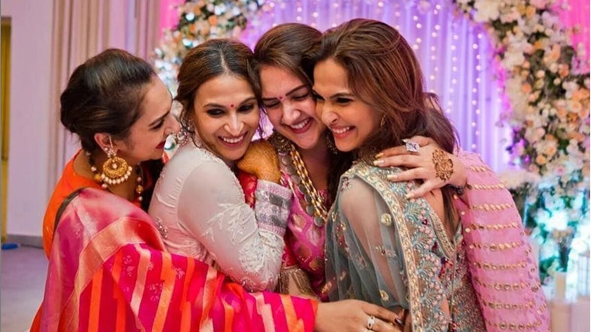 Soundarya Rajinikanth laughing in an embrace with three women in silk and embroidered outfits at a pre-wedding celebration