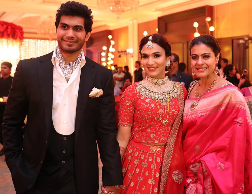 Soundarya Rajinikanth in a red bridal lehenga with Vishagan Vanangamudi and the actor Kajol at their wedding reception